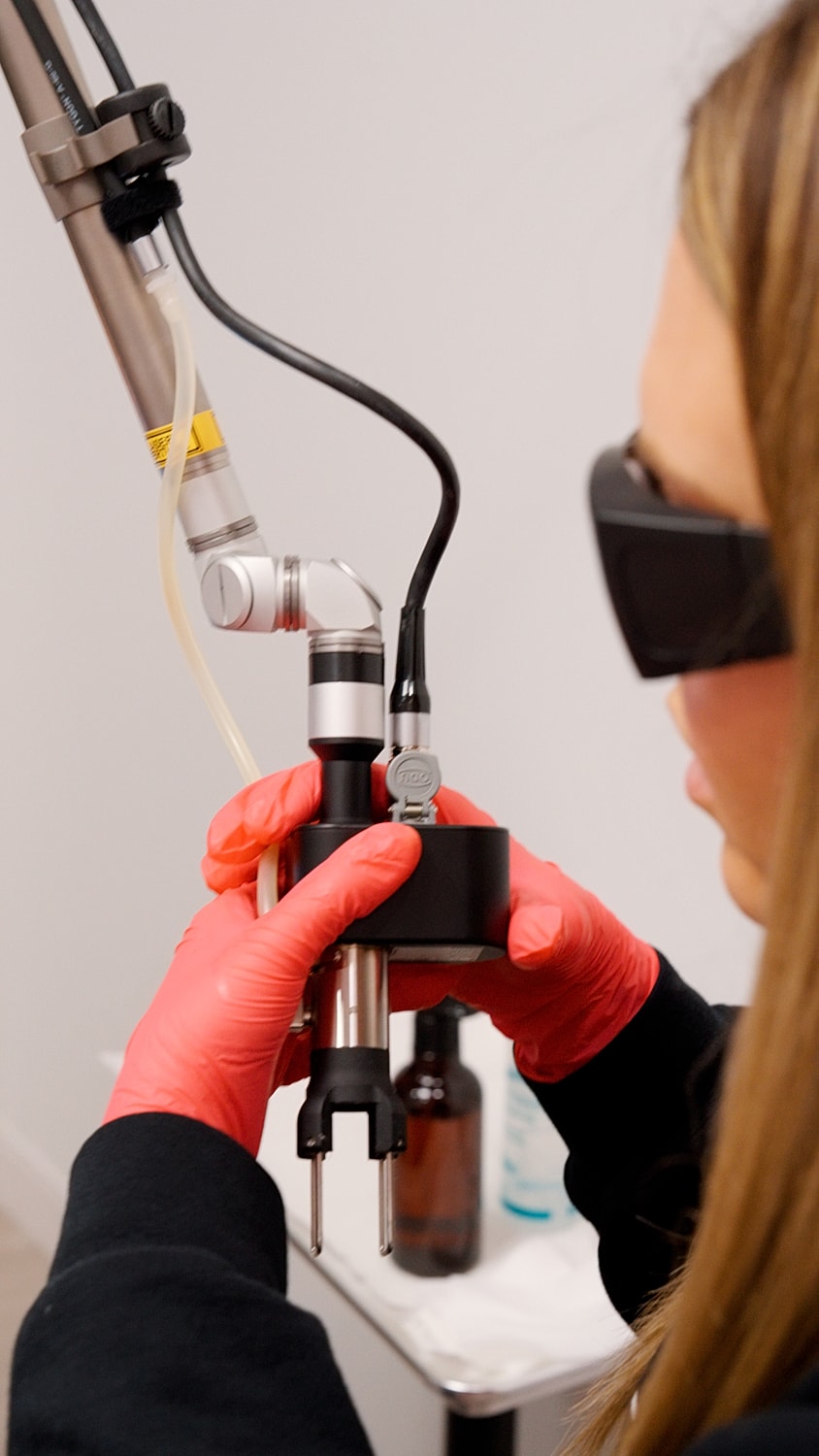 Woman examining lips in mirror at clinic.