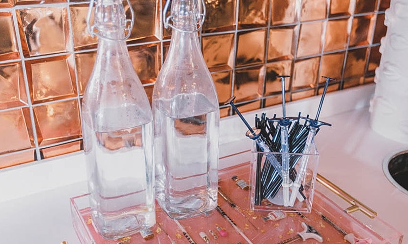 Water bottles and utensils on a countertop.