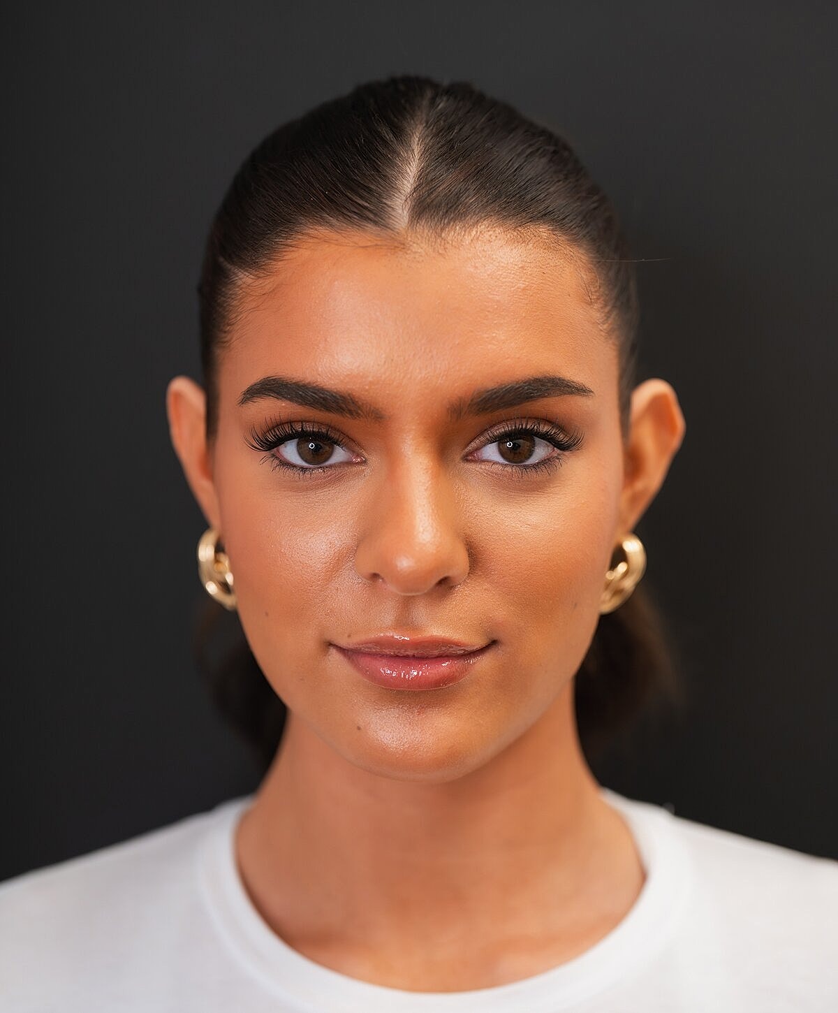 Woman examining lips in mirror at clinic.