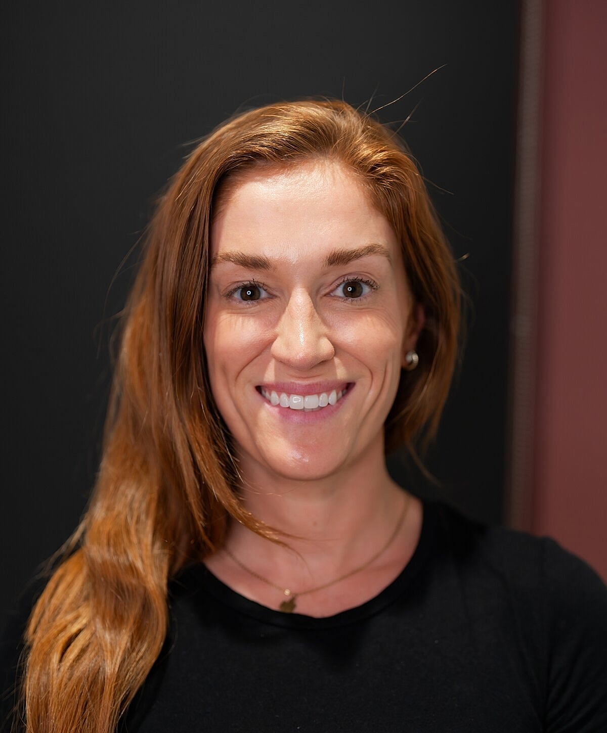 Woman examining lips in mirror at clinic.