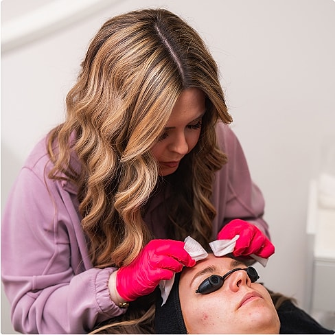 Beautician applying treatment to client's eyelashes.
