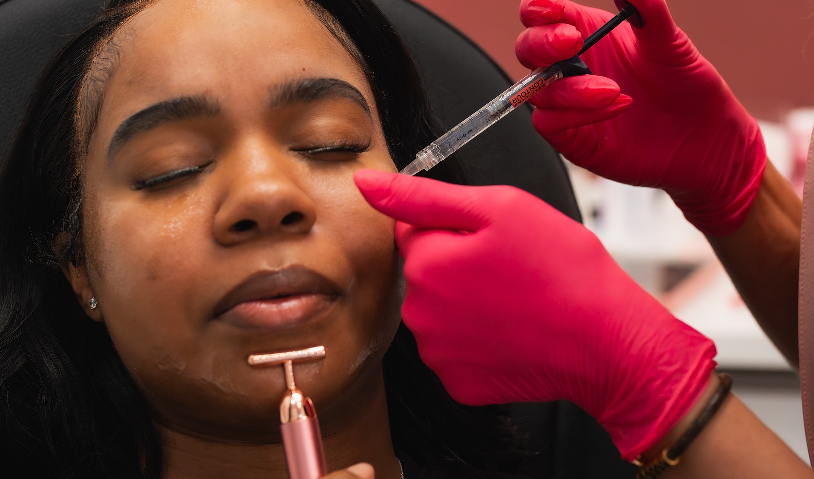 Facial treatment with syringe and roller tool.