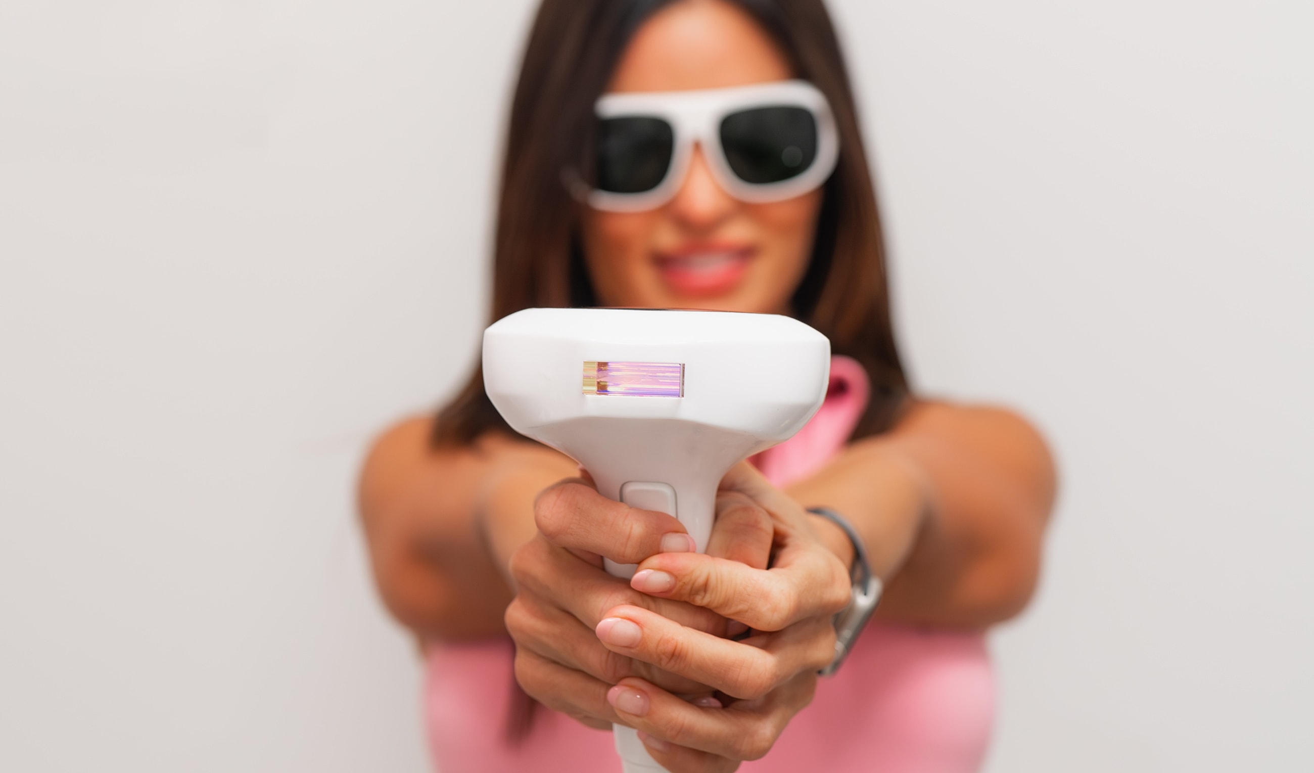 Woman holding a laser hair removal device.