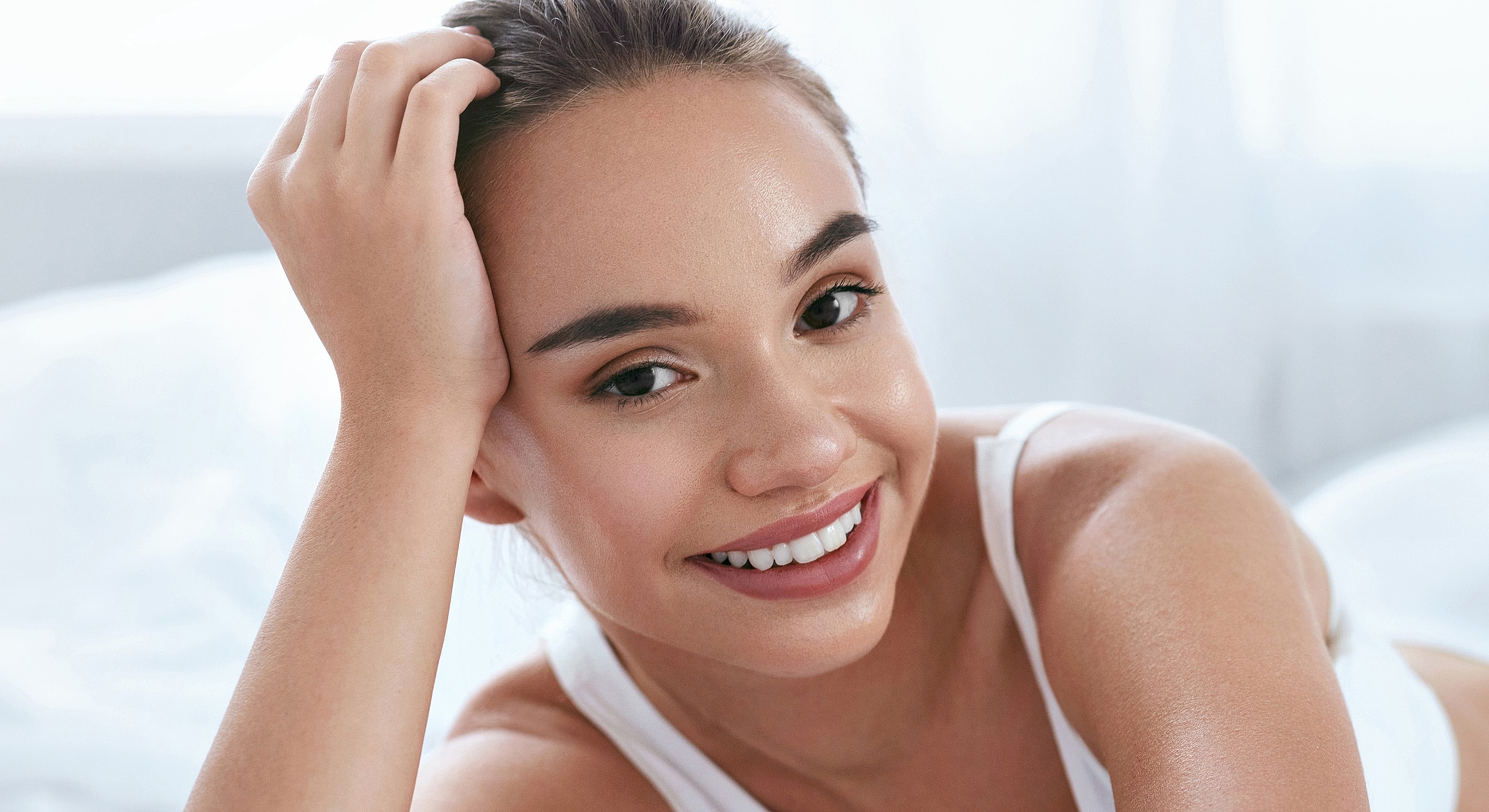 Smiling woman resting with hand on her head.